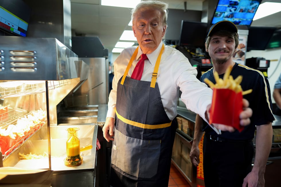 Republican presidential nominee former President Donald Trump, left, hands off an order of...