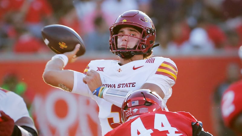 Iowa State quarterback Rocco Becht, back, looks to pass the ball under pressure from Houston...