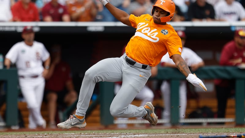 Tennessee infielder Christian Moore (1) slides safely into home base to score in the second...